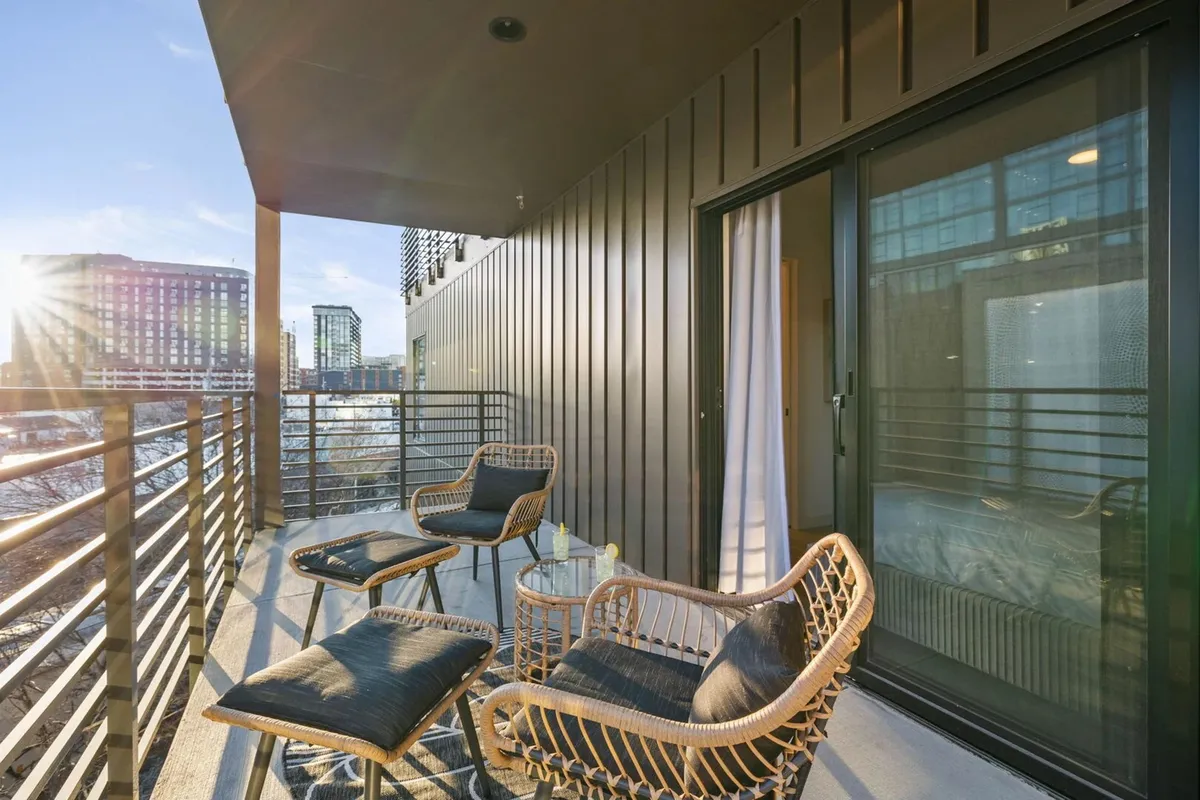 A private balcony with plush seating, a glass table, and sweeping city views. The tranquil setting is perfect for relaxing outdoors, whether enjoying sunrise coffee or evening drinks while overlooking Nashville's skyline.