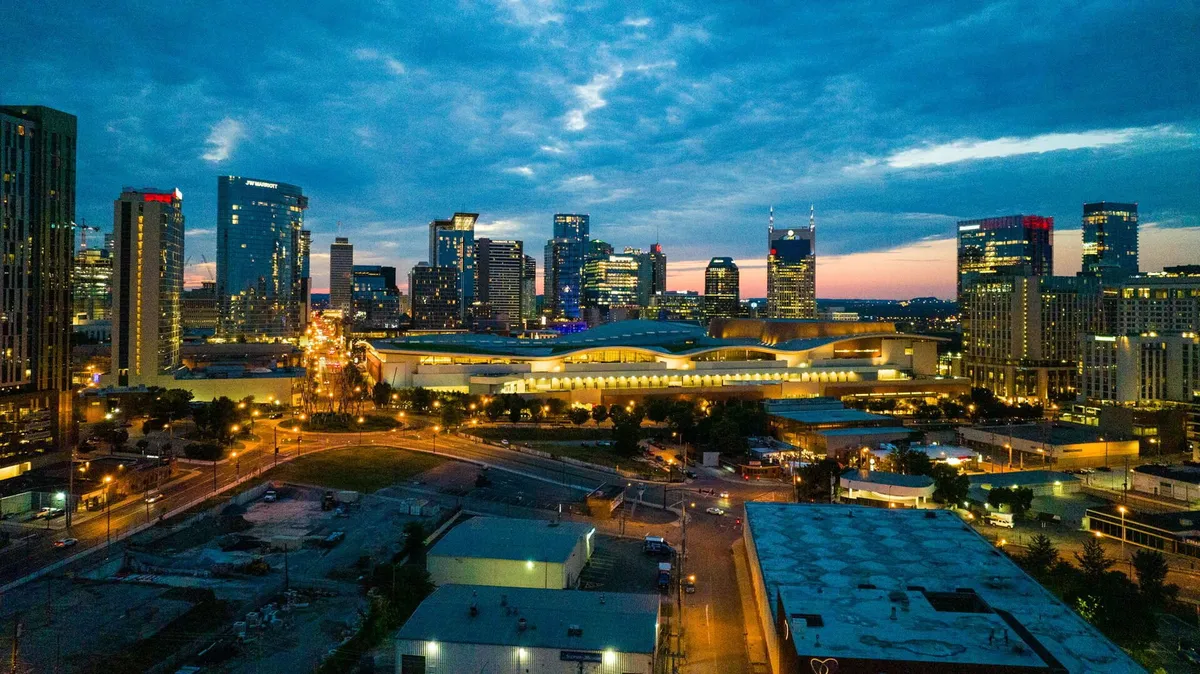 A panoramic view of Nashville’s city skyline at dusk, with illuminated buildings and a bustling thoroughfare. The energetic city vibe sets the scene for exploring concerts, festivals, and nightlife, as well as enjoying scenic views from balconies or rooftop lounges.