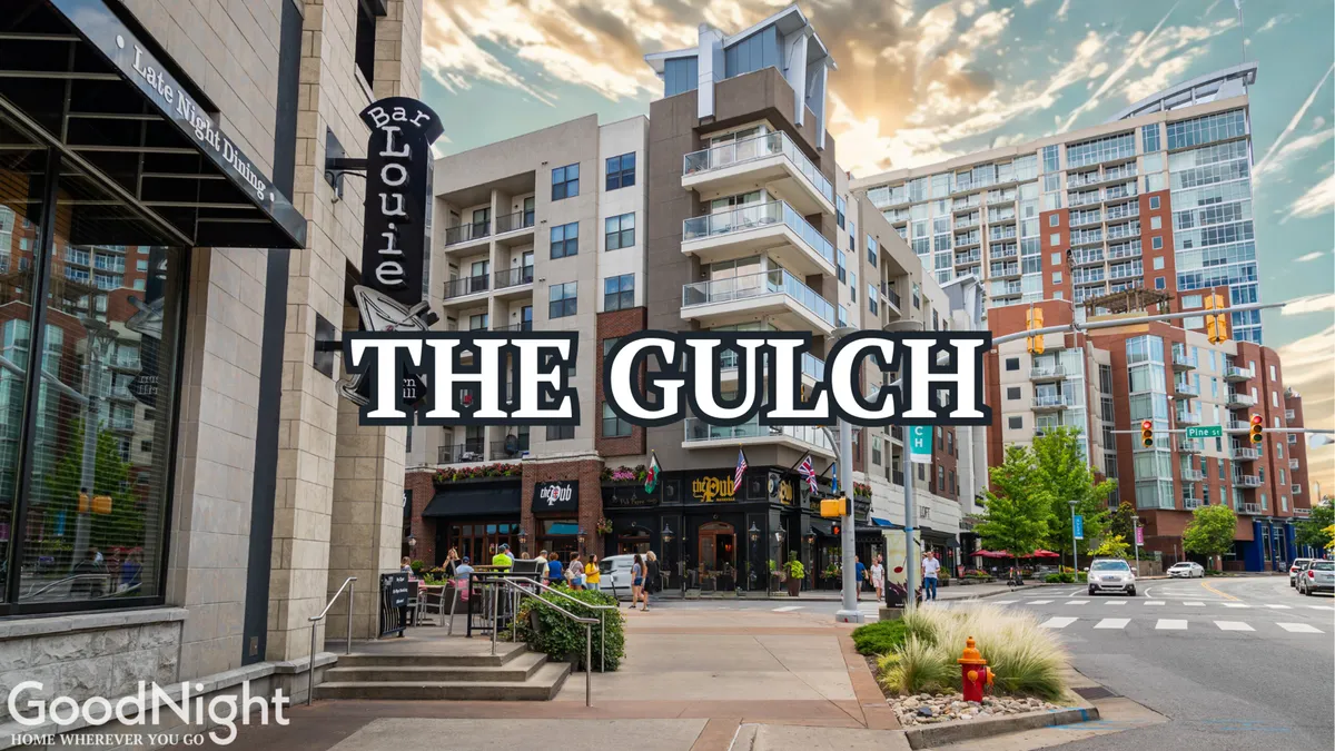 A bustling exterior scene at The Gulch, featuring the recognizable Bar Louie sign, modern buildings, outdoor seating, and people actively dining, shopping, and exploring the neighborhood.